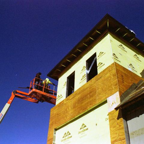 Crane next to second floor of building